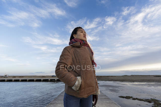 Giovane donna in piedi sul molo della spiaggia — Foto stock