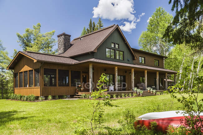 Brown e verde manchado casa país de madeira de abeto com varanda, Quebec, Canadá — Fotografia de Stock