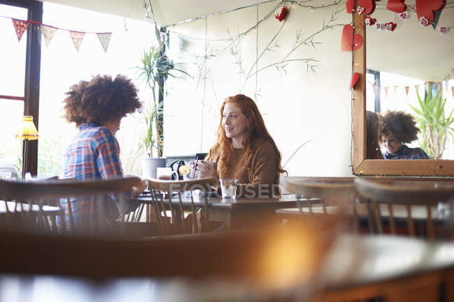 Dos mujeres jóvenes relajándose en la cafetería - foto de stock