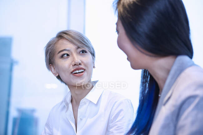 Mulher olhando colega sorrindo — Fotografia de Stock