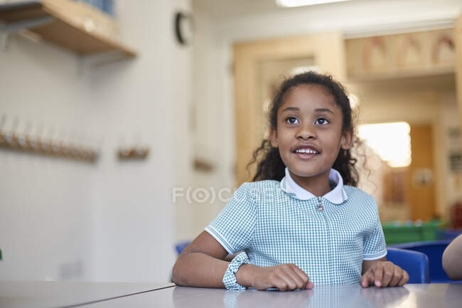 Schoolgirl listening in classroom lesson at primary school — Stock Photo