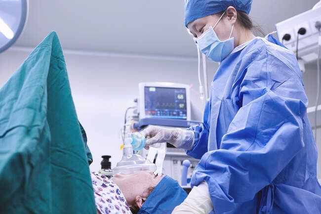 Anesthésiste surveillant la patiente en salle d'opération de maternité — Photo de stock