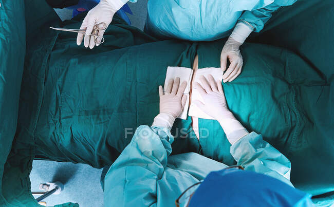 Vue aérienne des chirurgiens opérant sur l'abdomen dans le bloc opératoire de la maternité — Photo de stock