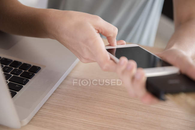 Junge Frau nutzt Smartphone am Schreibtisch — Stockfoto