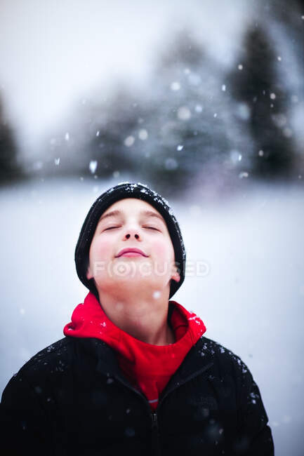 Portrait of boy in falling snow — Stock Photo