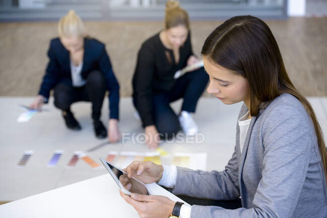Молода бізнес-леді в офісі дивиться на цифровий планшет — стокове фото