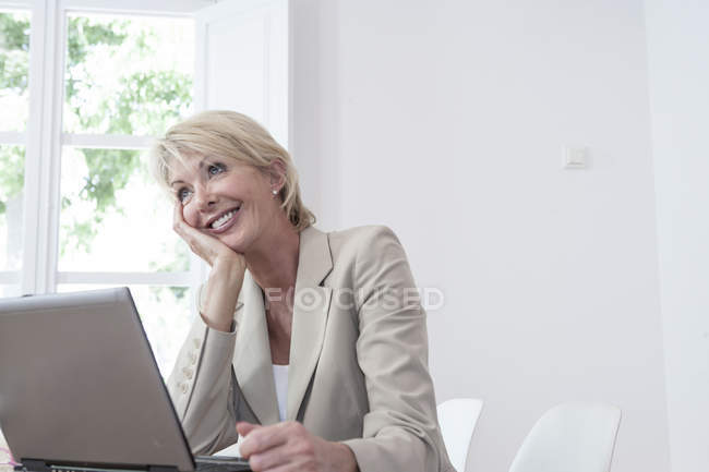 Business woman, hand on chin looking away smiling — Stock Photo