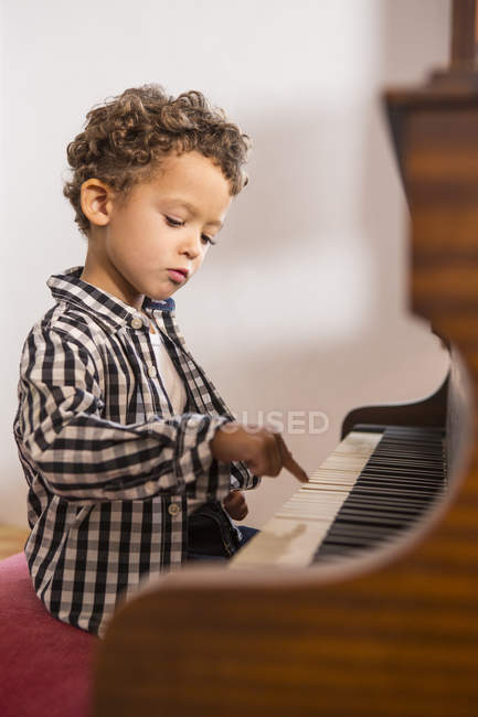 Four year old boy playing on piano — Stock Photo