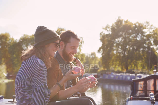 Pareja comiendo cupcakes en barco del canal - foto de stock