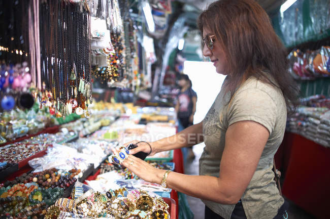 Frau betrachtet Souvenirs am Marktstand, Bangkok, Krung Thep, Thailand, Asien — Stockfoto