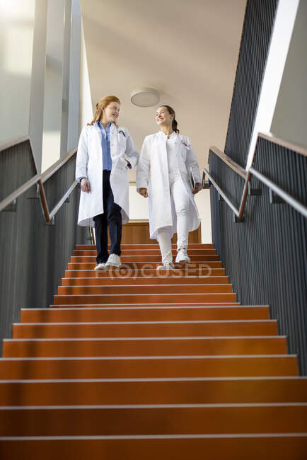 Two female doctors walking down steps, low angle view — Stock Photo