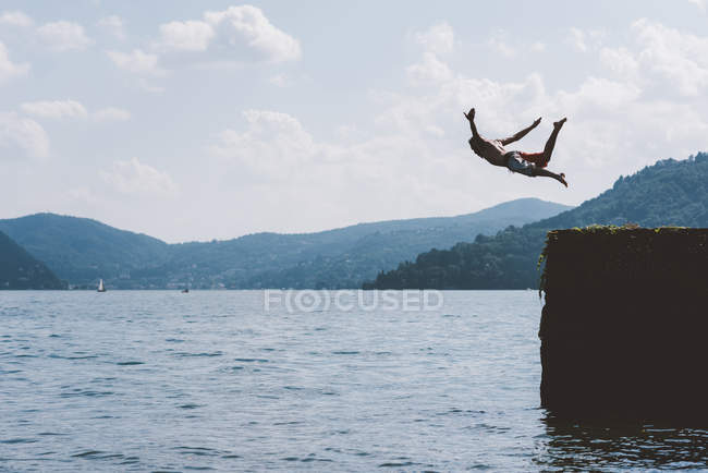 Jovem nadador do sexo masculino mergulho no cais, Lago de Como, Lombardia, Itália — Fotografia de Stock