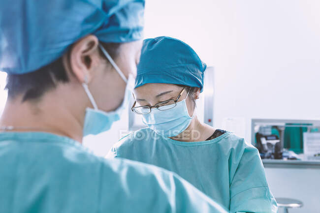 Over shoulder view of surgeon performing operation in maternity ward operating theatre — Stock Photo