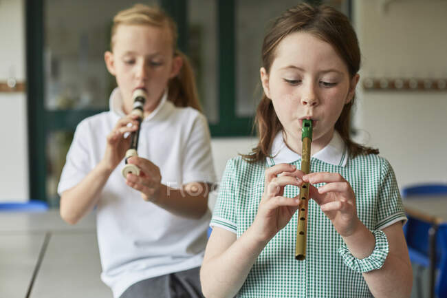Schülerinnen spielen Blockflöte im Klassenzimmer der Grundschule — Stockfoto