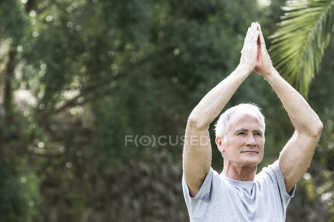 Чоловік, руки разом, руки підняті в положенні йоги — стокове фото