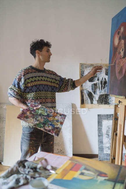 Artista masculino pintura sobre tela em estúdio — Fotografia de Stock