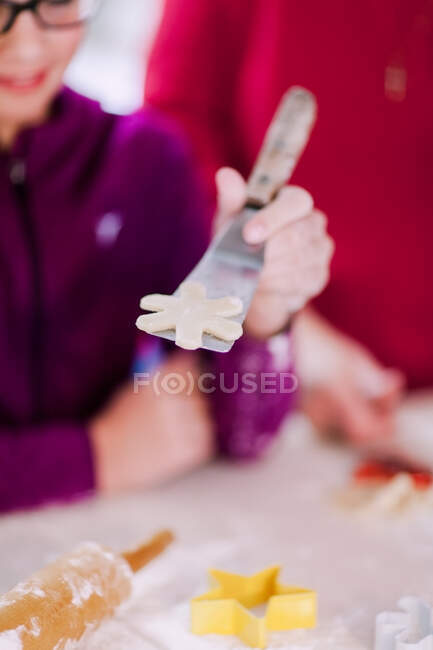Fille et grand-mère avec pâte à biscuits étoile sur spatule — Photo de stock