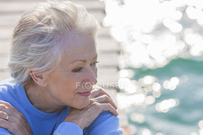 Porträt einer Seniorin, die aufs Meer blickt — Stockfoto