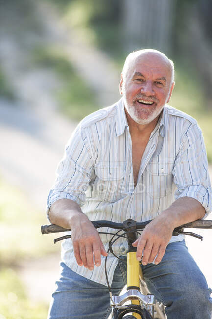 Portrait of senior man on bicycle — Stock Photo