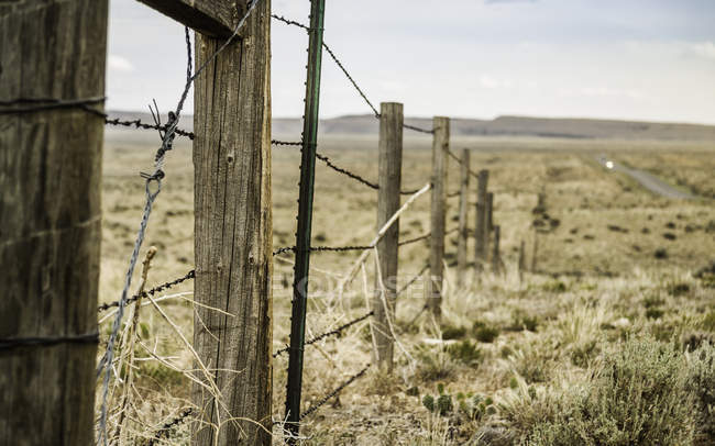 Esgrima a través del paisaje rural, Montana, EE.UU. - foto de stock