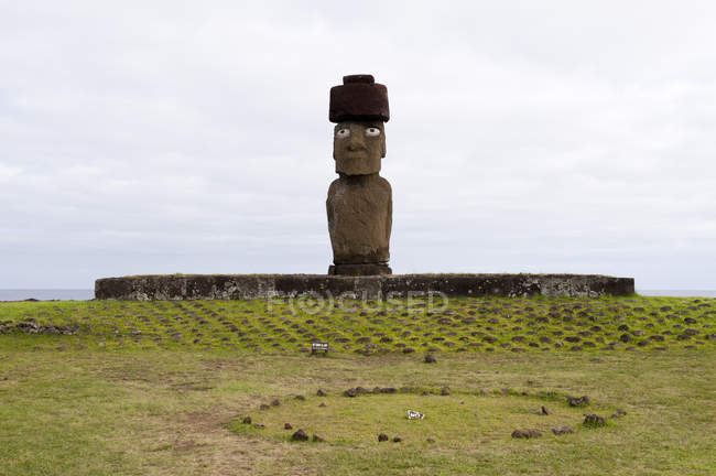 Vista lejana de estatua de piedra en colina verde, Isla de Pascua, Chile - foto de stock