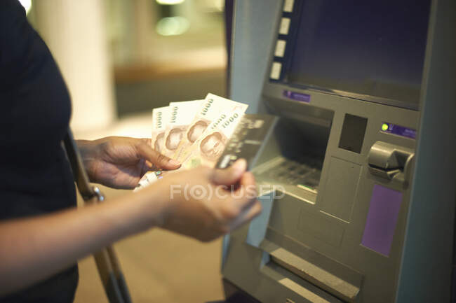 Vista recortada de la mujer retirando dinero de cajero automático - foto de stock