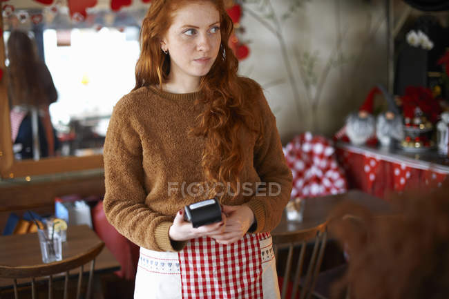 Waitress in cafe holding credit card reader — Stock Photo