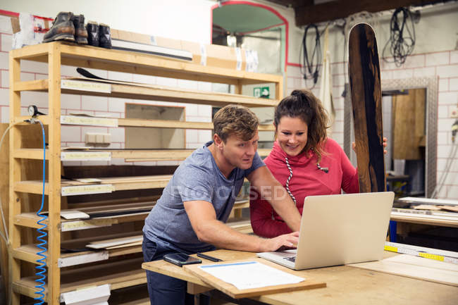 Mann und Frau mit Laptop in Werkstatt — Stockfoto