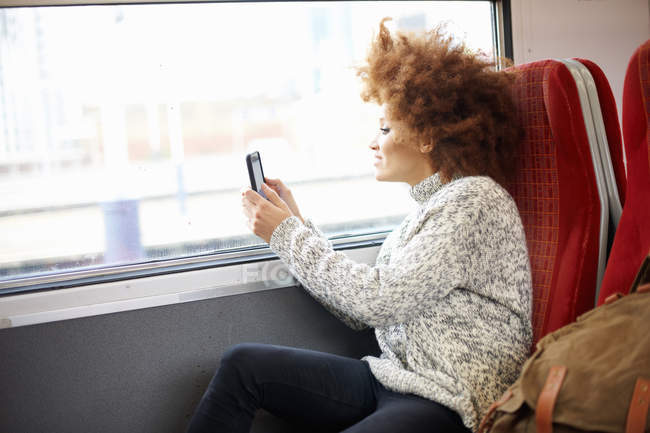 Donna che scatta foto con il cellulare dal treno — Foto stock