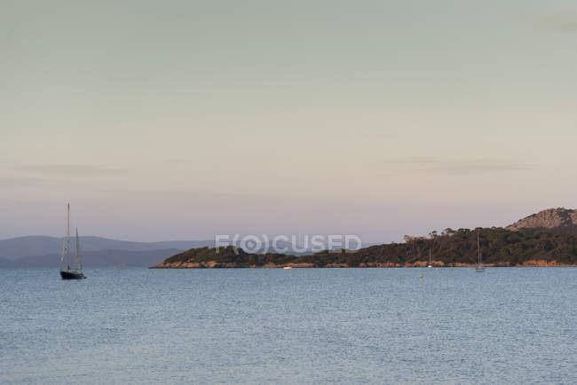 Vista de la costa y el yate anclado, Porquerolles, Provenza-Alpes-Costa Azul - foto de stock