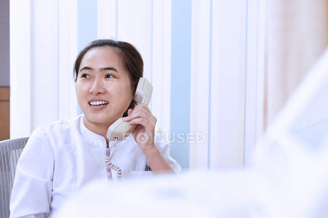 Médecin femme faisant un appel téléphonique — Photo de stock