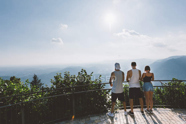 Vista traseira dos amigos olhando para o lago Como a partir da varanda, Como, Lombardia, Itália — Fotografia de Stock