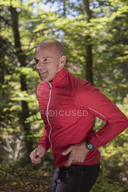 Mature male runner running in woodland — Stock Photo