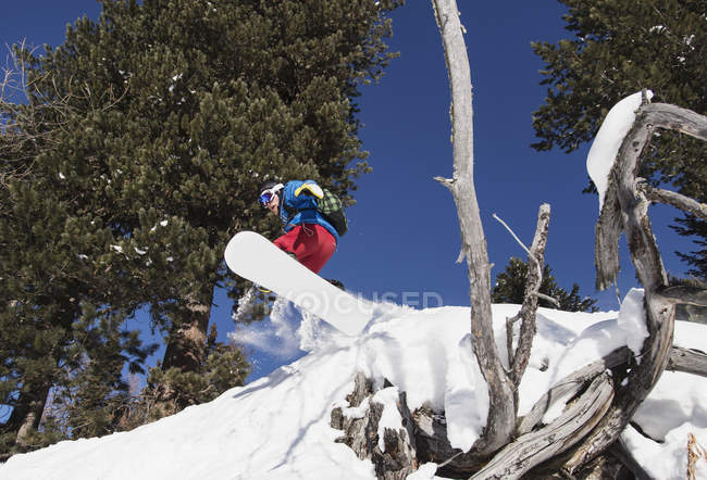 Snowboarder masculin embarquant sur le flanc de montagne — Photo de stock