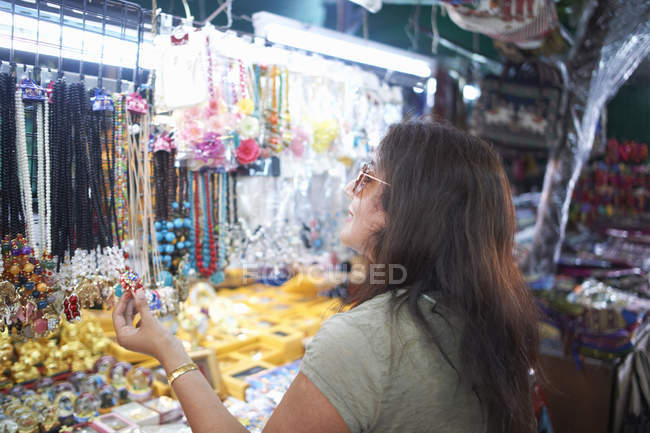 Женщина смотрит на сувениры на рынке киоска, Бангкок, Крунг Теп, Таиланд, Азия — стоковое фото