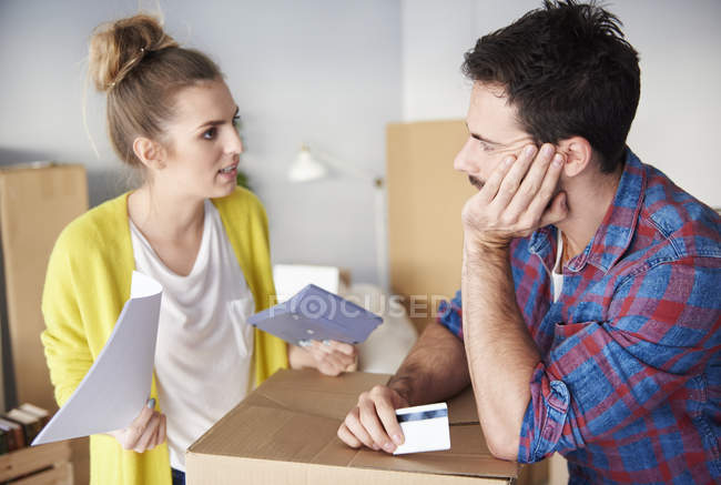 Jovem casal cercado por caixas de papelão trabalhando para fora finanças — Fotografia de Stock