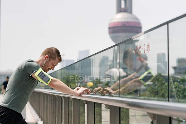 Giovane corridore appoggiato al corrimano, Shanghai, Cina — Foto stock