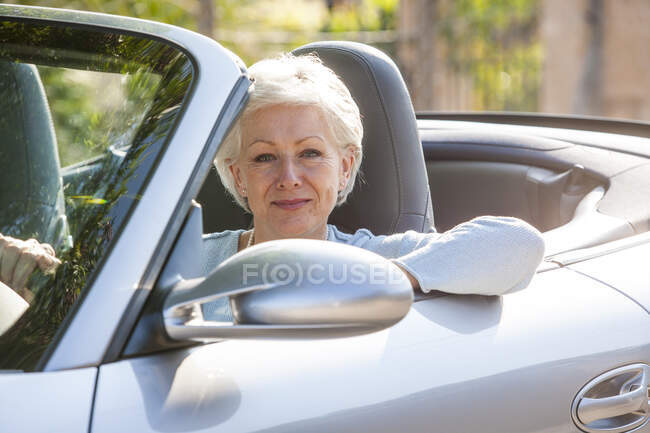 Retrato de mulher idosa em carro conversível — Fotografia de Stock