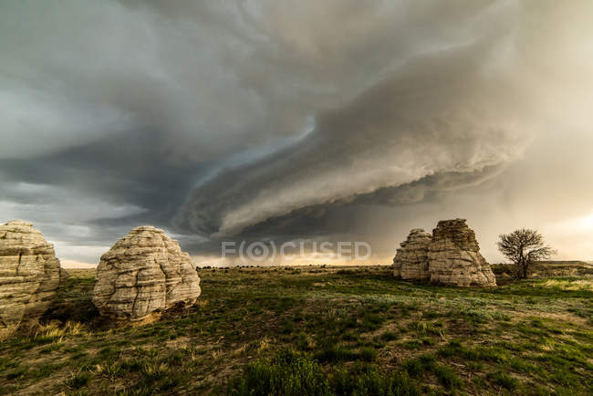 Storm clouds over rock formations in field, Lamar, Colorado, United States, North America — Stock Photo