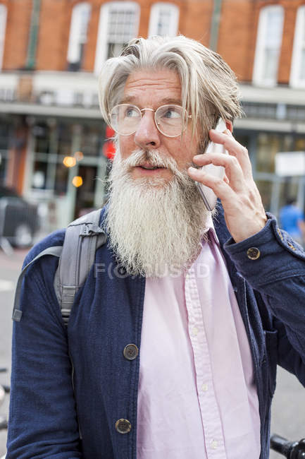 Mature man using smartphone outdoors — Stock Photo