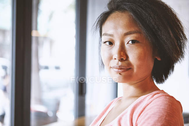 Portrait of woman with nose piercing in cafe, Shanghai French Concession, Shanghai, China — Stock Photo