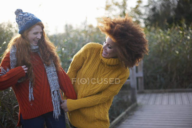Friends arm in arm laughing in rural setting — Stock Photo