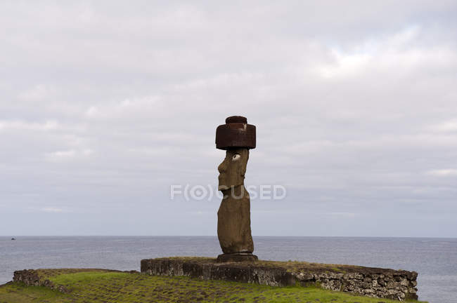 Vista lejana de estatua de piedra en colina verde, Isla de Pascua, Chile - foto de stock