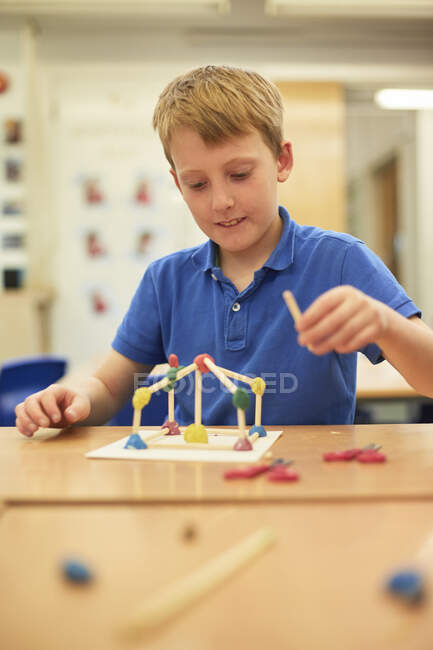 Schoolboy making ball and stick model in classroom at primary school — Stock Photo