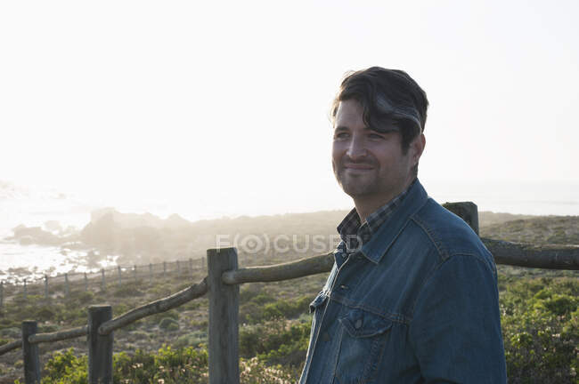 Retrato de hombre adulto medio feliz mirando hacia la costa, Ciudad del Cabo, Cabo Occidental, Sudáfrica - foto de stock