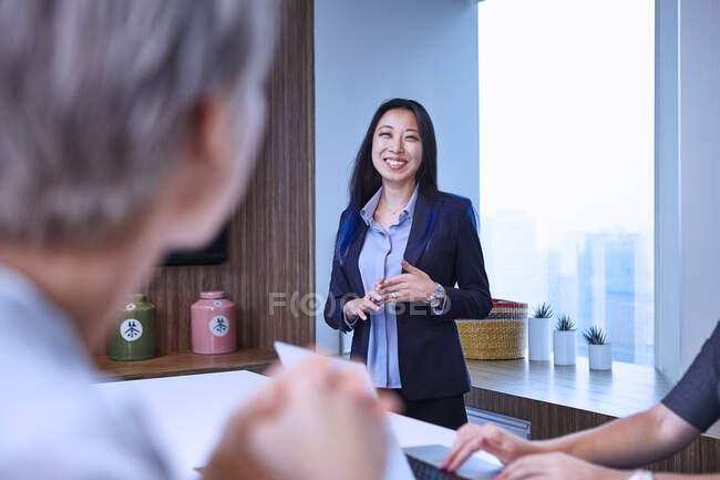 Donna d'affari in riunione in sala riunioni, guardando il collega sorridente — Foto stock