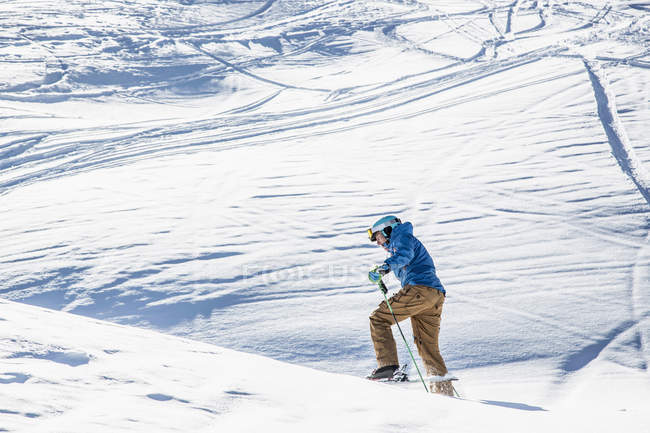 Skieur masculin chevauchant sur une colline de montagne — Photo de stock