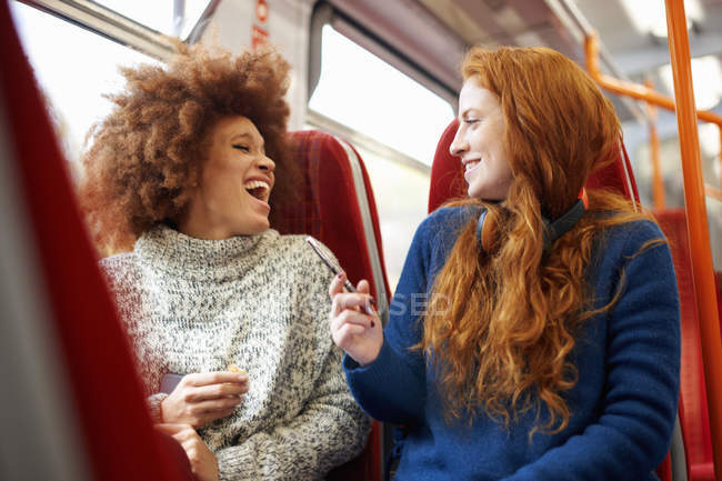 Two female friends laughing in train — Stock Photo