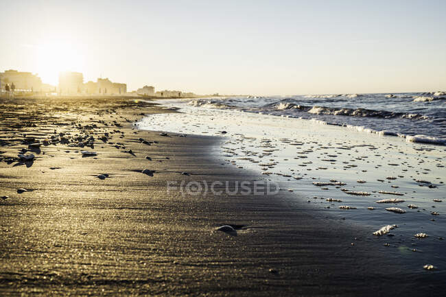 Vue du bord de l'eau sur la plage au coucher du soleil, Riccione, Emilie-Romagne, Italie — Photo de stock
