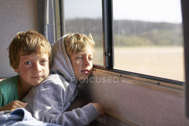 Boys sitting in campervan looking out of window, Polonio, Rocha, Uruguay, South America — Stock Photo